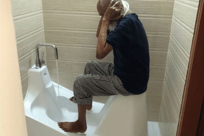 WuduMate Classic being used by a 100-year-old Muslim gentleman in a home bathroom.